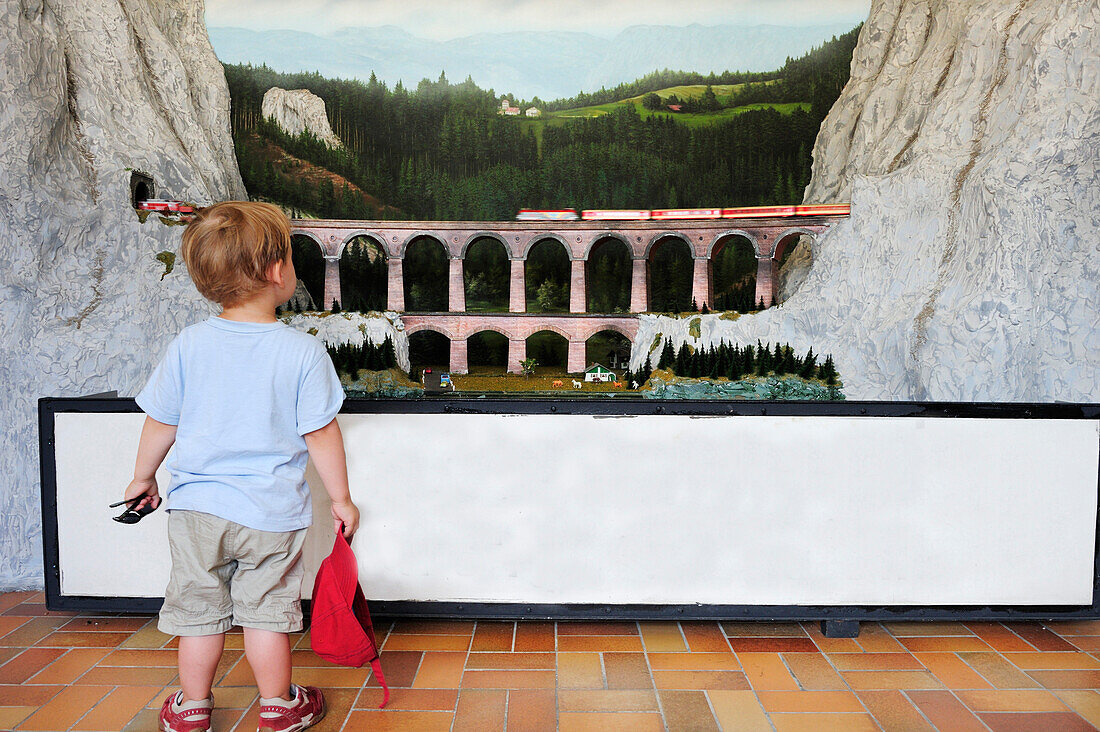 Kleiner Junge schaut auf Modelleisenbahn, Bahnhof Semmering, Semmeringbahn, UNESCO Weltkulturerbe Semmeringbahn, Niederösterreich, Österreich