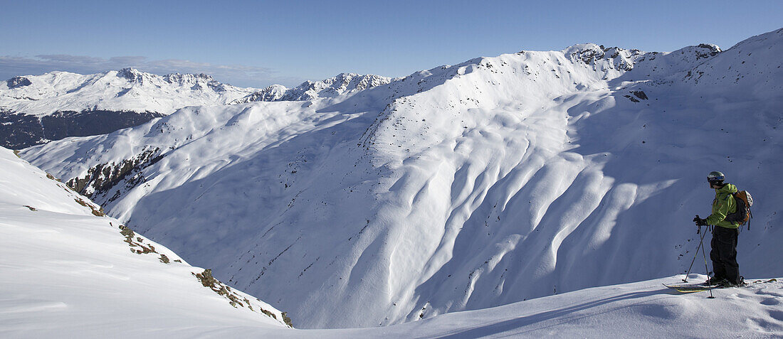Skier in front of mountain range, Pischa, Davos, Canton of Grisons, Switzerland