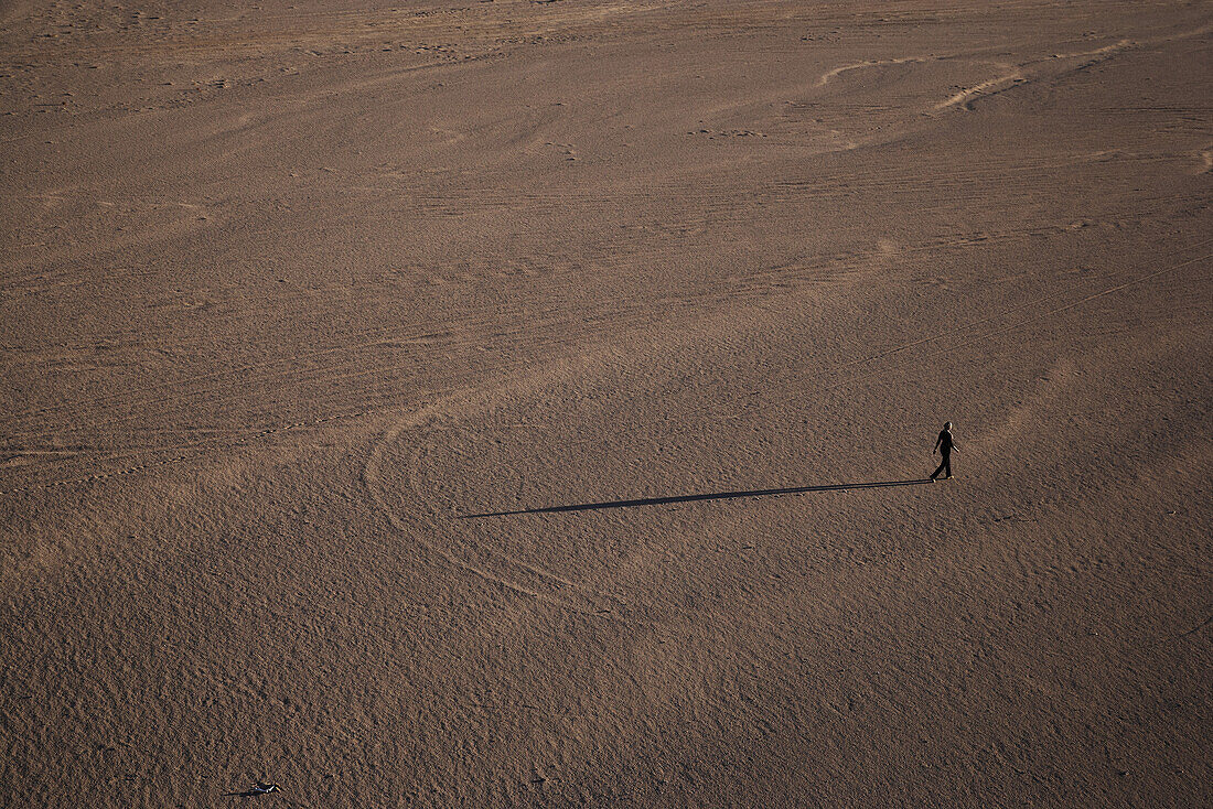 Woman walking in desert, Sudan, Africa