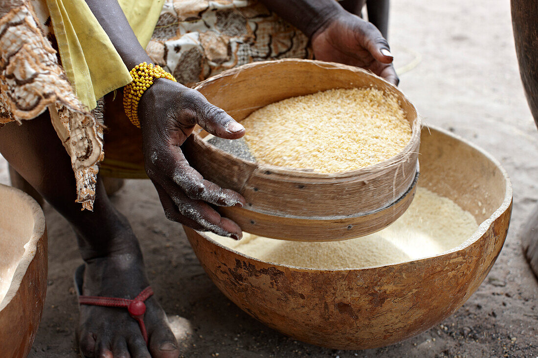 Woman sieving cornmeal, Bougouni, Mali, Africa