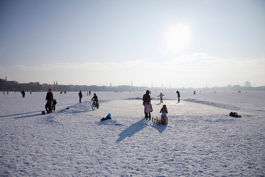 Menschen auf der zugefrorenen Außenalster im Winter, Hamburg, Deutschland
