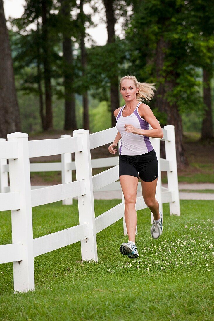 30 Jahre alte blonde Frau beim Joggen in Trainingskleidung