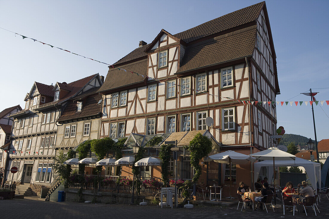 People enjoying an ice cream whilst seated outside a timberframe house in the old town, Rotenburg an der Fulda, Hesse, Germany, Europe