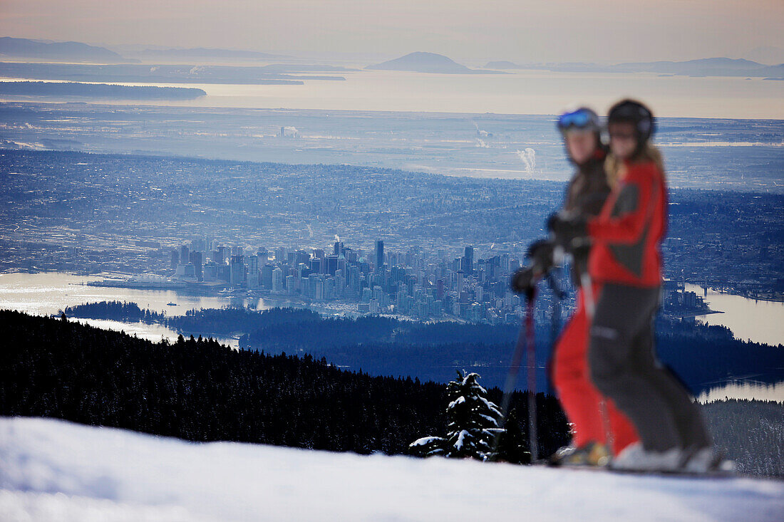 Skiers on slope, Vancouver in background, British Columbia, Canada