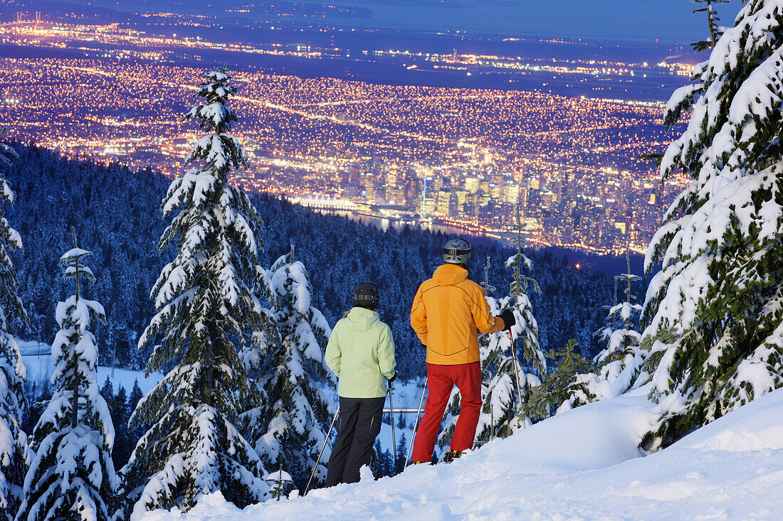 Skifahrer blicken auf Vancouver am Abend, British Columbia, Kanada
