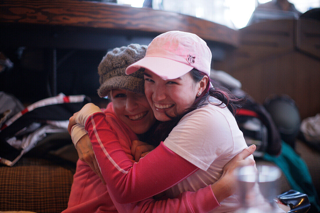 Two women embracing each other, Apres-ski bar, Whistler, British Columbia, Canada