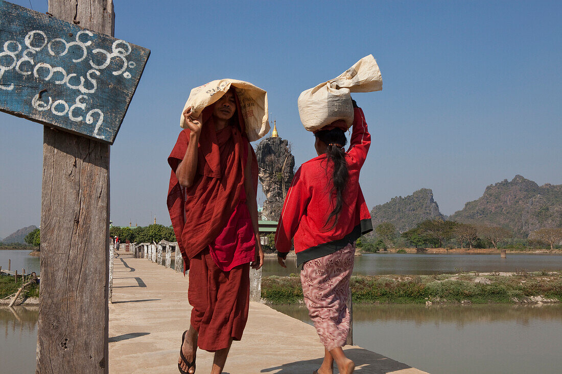 Buddhistic monk on the bridge to the Kyauk Ka Lat Pagoda on a rock, Kayin State, Myanmar, Birma, Asia