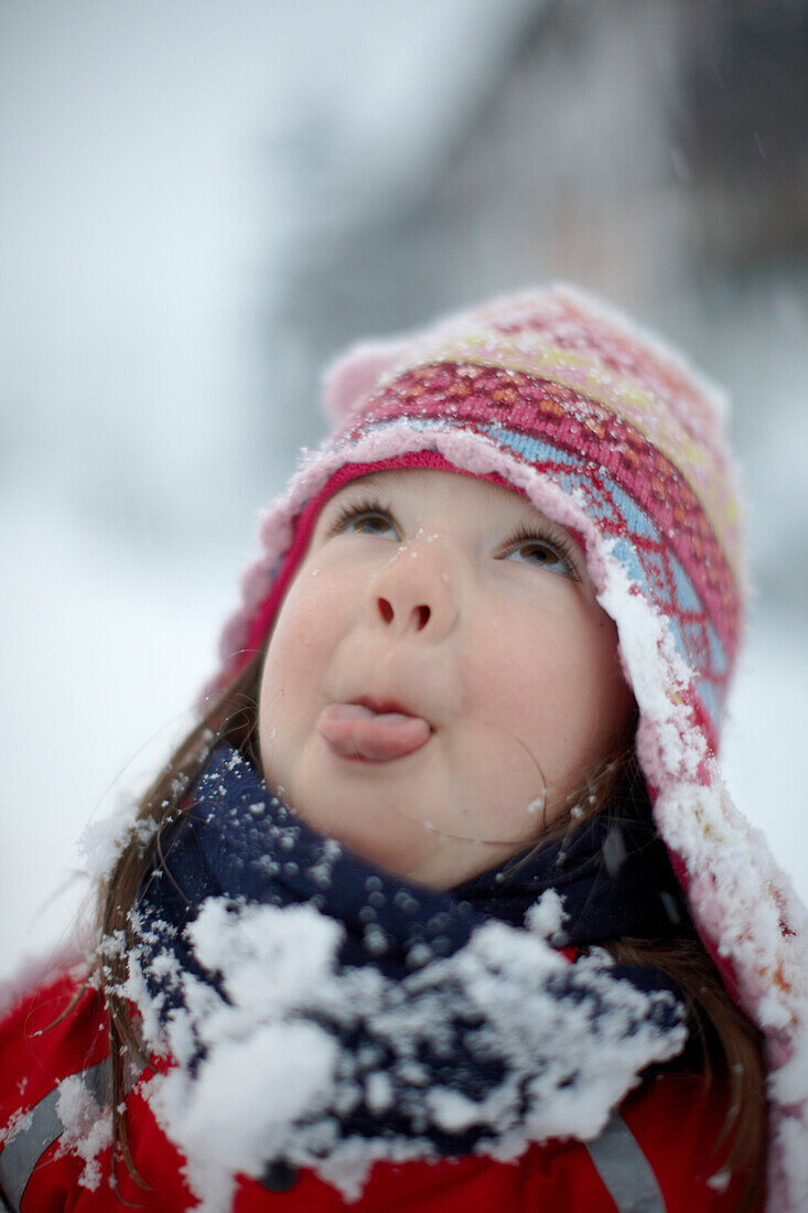 Girl (5 years) catching snowflakes on tongue, skiing area Heuberg, Hirschegg, Kleinwalsertal, Vorarlberg, Austria