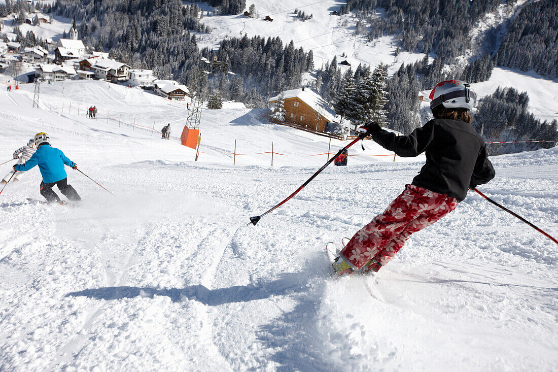Kinder fahren Ski, Schlößlelift, Blick auf Hirschegg, Kleinwalsertal, Vorarlberg, Österreich