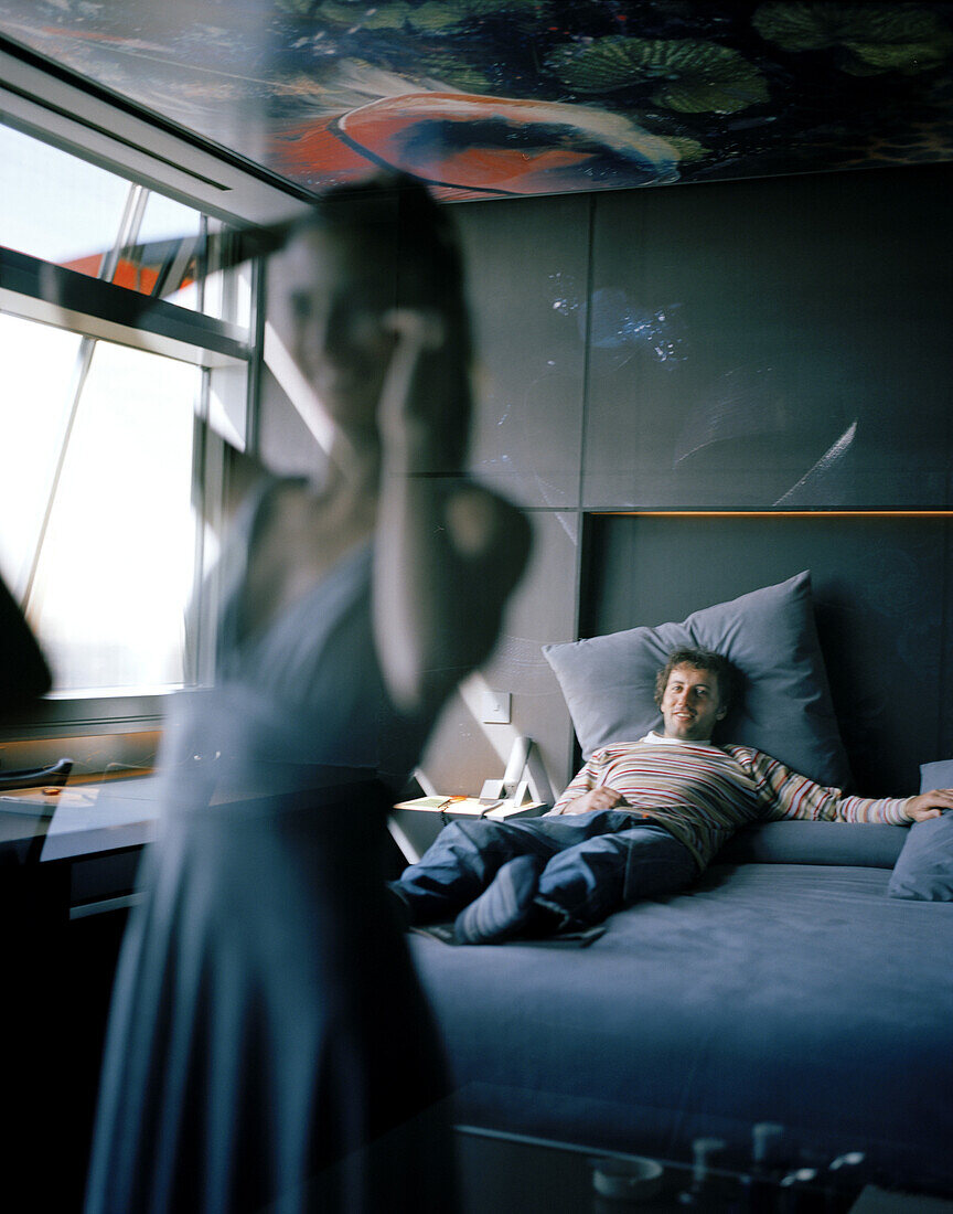 Spiegelung einer Frau beim Anziehen, Mann schaut zu, Suite, 13. Stockwerk, Gestaltung Jean Nouvel, Hotel Silken Puerta America, Madrid, Spanien