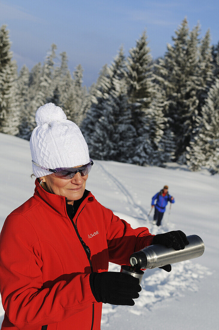 Menschen wandern auf Winterwanderweg in verschneiter Landschaft, Hemmersuppenalm, Reit im Winkl, Chiemgau, Bayern, Deutschland, Europa
