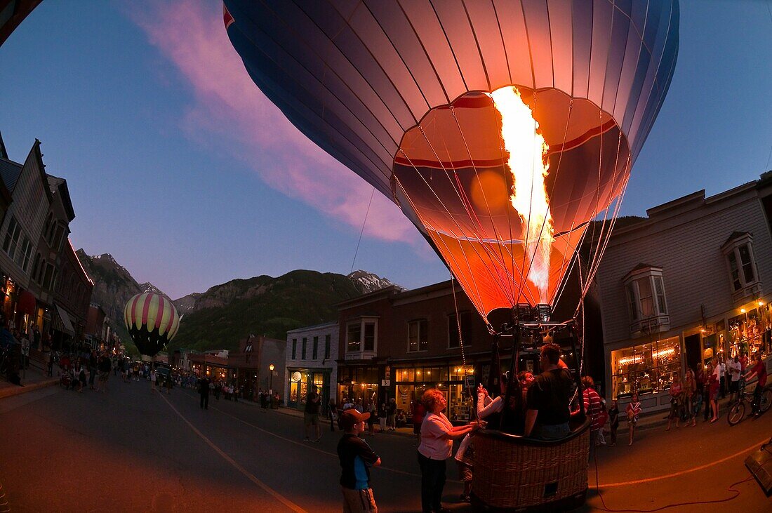 Hot air balloons illuminated at night by their propane burners, Telluride Balloon Festival, Main Street, Telluride, Colorado USA