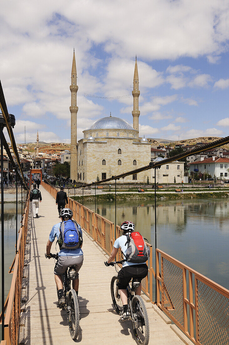 Mountainbiker on the bridge in the front of a mosque, Avanos, Cappadocia, Turkey, Göreme, Cappadocia, Turkey