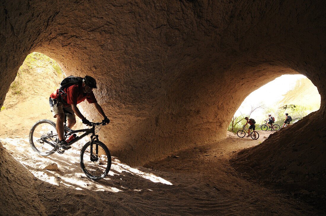 Mountainbiker in the tonnel of a river, Uchisar, Göreme, Cappadocia, Turkey