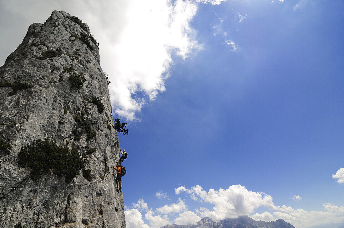 View at couple at rock face, Schuasta Gangl, Gamssteig fixed rope route, Steinplatte, Reit im Winkl, Chiemgau, Upper Bavaria, Bavaria, Germany, Europe