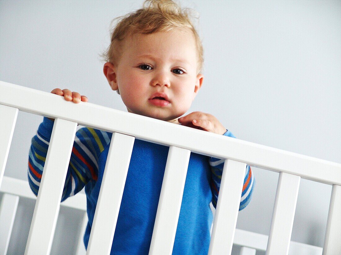 Child standing in a crib.
