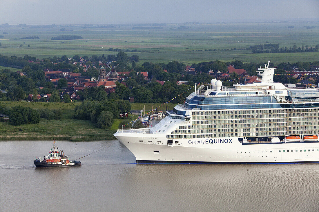 Tug boat navigating the newly launched Celebrity Equinox from the Meyer Werft along the River Ems, Lower Saxony, Germany