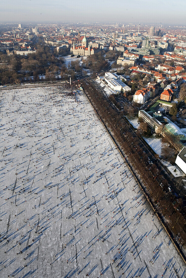 Aerial view of frozen lake Maschsee, New Town Hall and city of Hannover in the winter snow, Lower Saxony, Germany