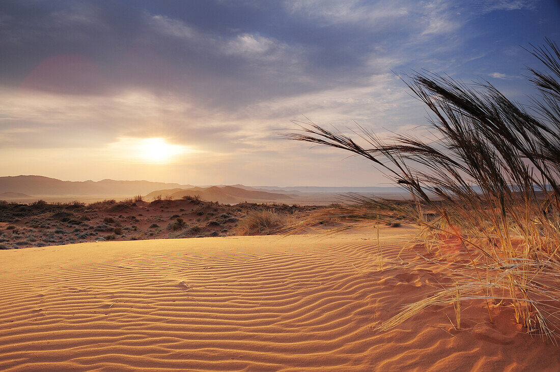 Sonnenaufgang über roter Sanddüne mit Tirasberge im Hintergrund, Namibwüste, Namibia