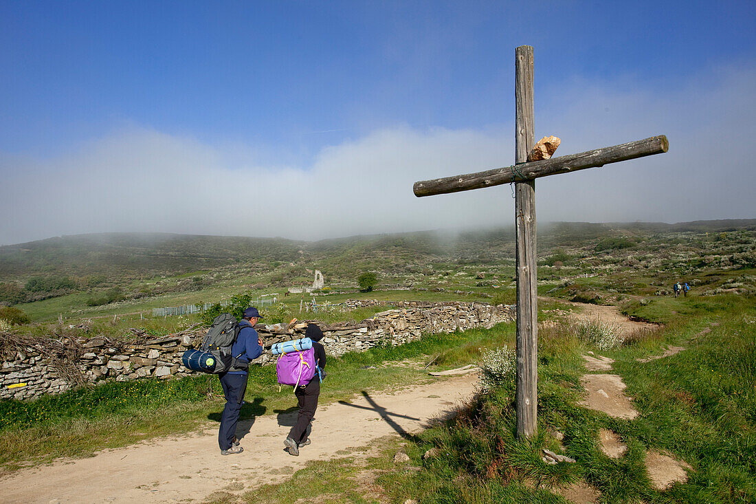 Pilgrims at a wayside cross in the sunlight, Province of Leon, Old Castile, Castile-Leon, Castilla y Leon, Northern Spain, Spain, Europe