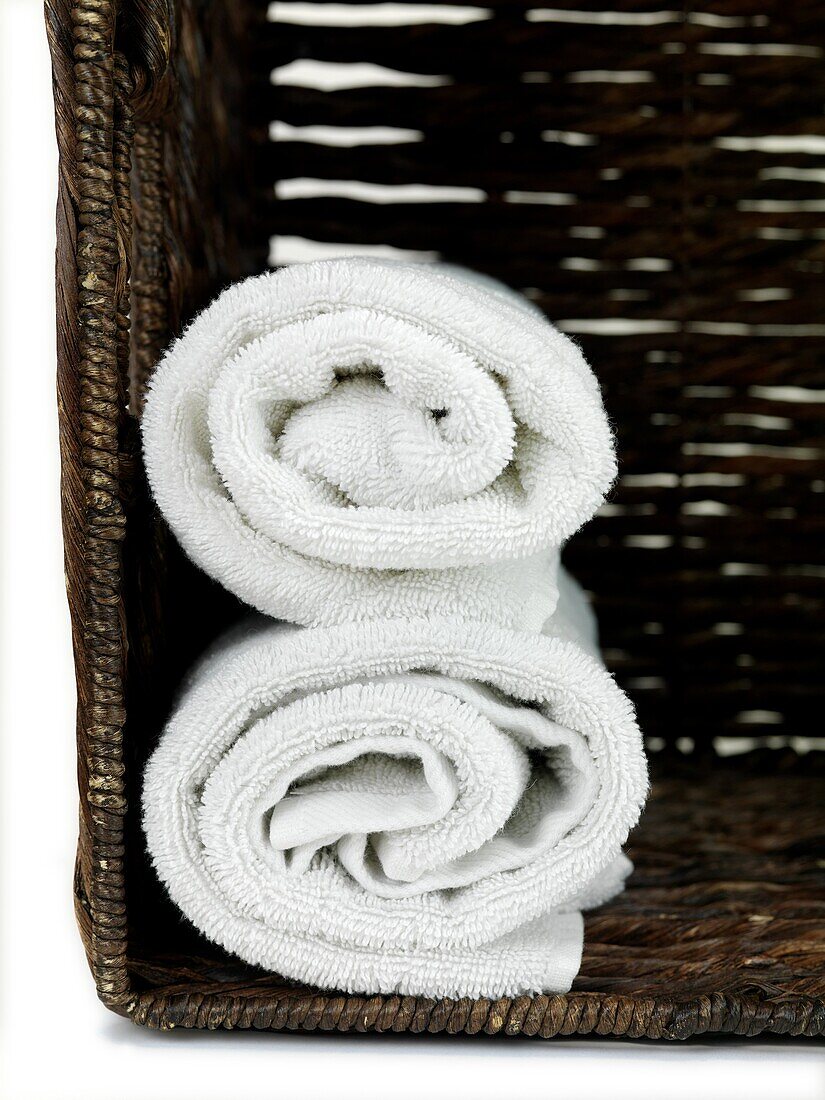 A stack of bath towels isolated in a wicker basket