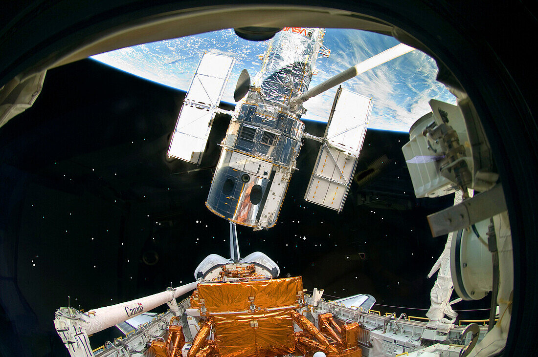 The Space Shuttle Atlantis,  robotic arm lifts the Hubble Space Telescope from the cargo bay on May 19, 2009, moments away from releasing the observatory to resume its travels around Earth The release concluded Servicing Mission 4, the fifth astronaut vis