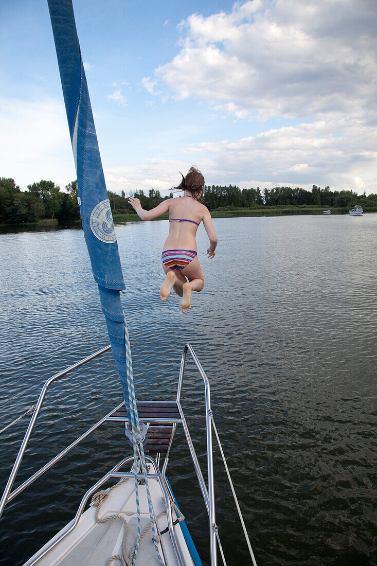 Girl jumping from a sailing boat into lake Beetzsee, Brandenburg an der Havel, Brandenburg, Germany
