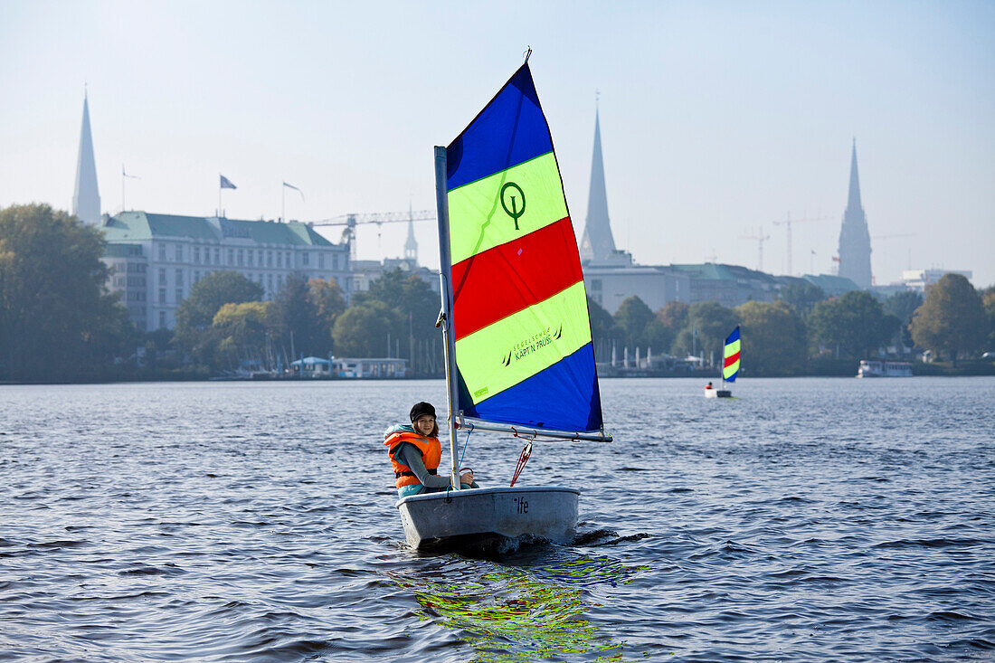 Mädchen segelt in einer Jolle Optimist auf der Außenalster, Hamburg, Deutschland