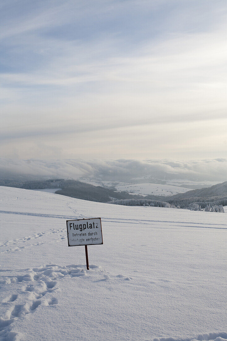 Sign in snow- covered landscape at Wasserkuppe, near Gersfeld, low mountain range, Rhoen, Hesse, Germany