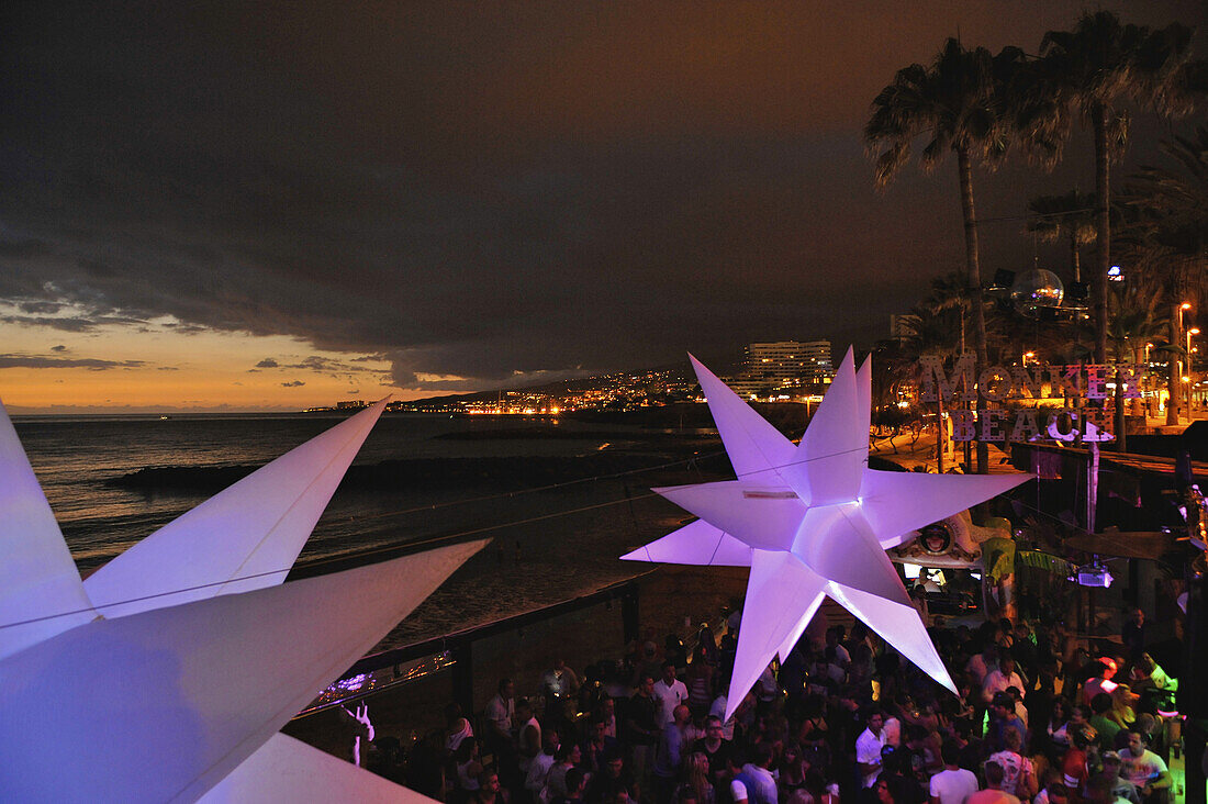 Visitors dance at sundown in the disco at Monkey Beach, Playa de las Americas,  South  Tenerife, Spain