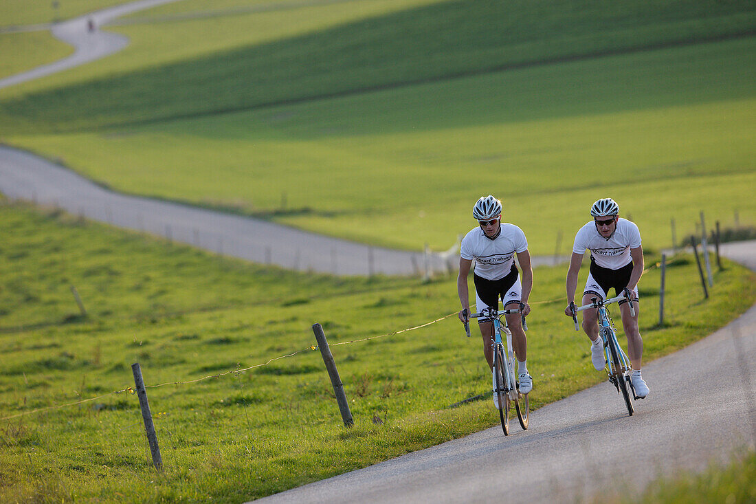 Two racing cyclists on road near Munsing, Upper Bavaria, Germany