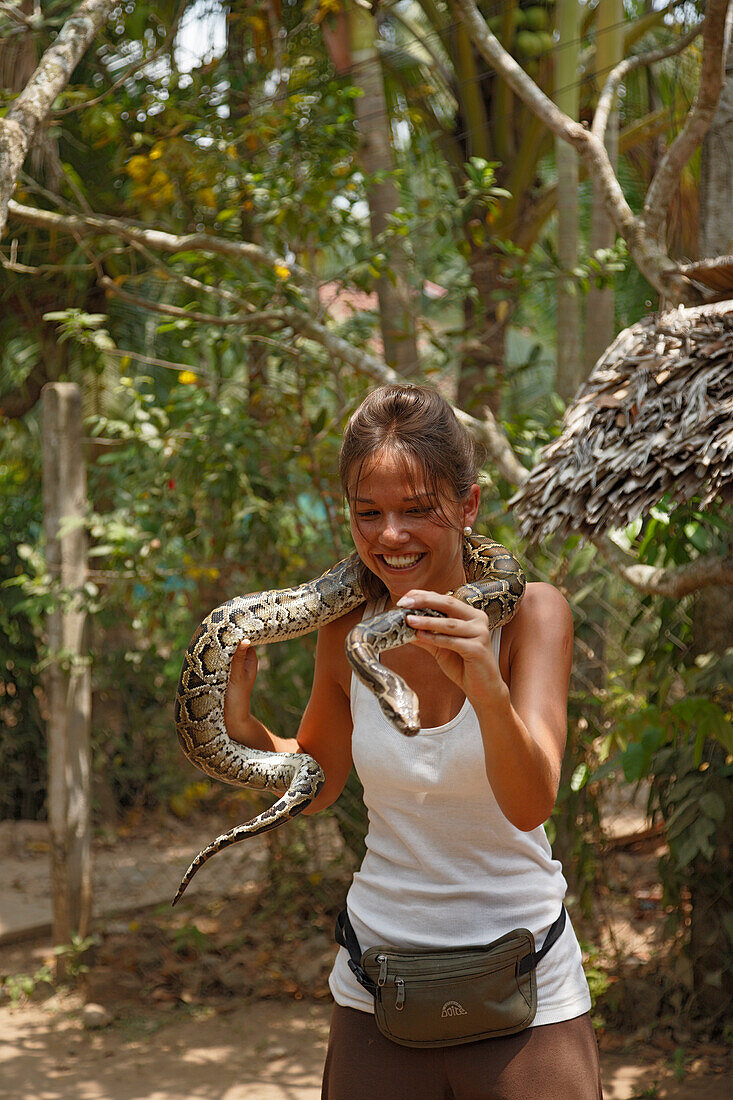 Woman holding snake, Mekong, Vietnam