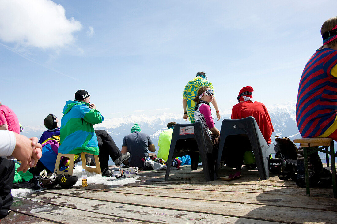 Junge Leute sitzen auf der Terrasse vom Café No Name, Skigebiet Flims Laax Falera, Laax, Graubünden, Schweiz
