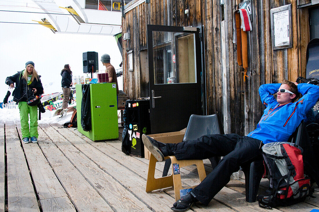 Young people resting on terrace of Café No Name, Skigebiet Flims Laax Falera, Laax, Graubünden, Schweiz