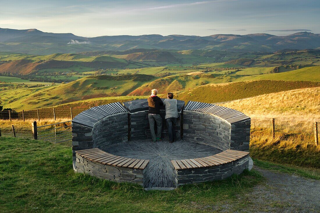 A couple of tourists admiring the view of north powys from the Wynford Vaughan Thomas memorial viewpoint near Machynlleth mid wales UK