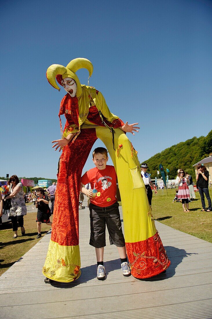 A jester harlequin stilt walker at the The Urdd National Eisteddfod 2010, Llanerchaeron Ceredigion Wales UK