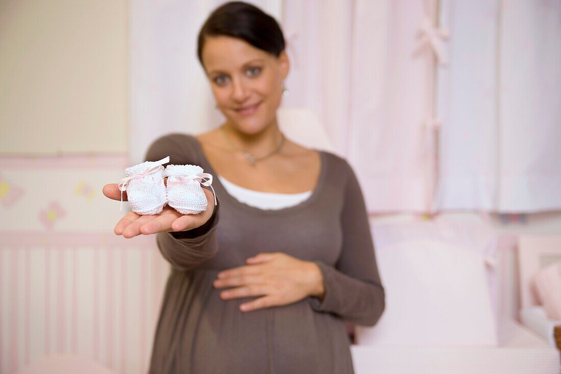 Pregnant woman with baby booties.