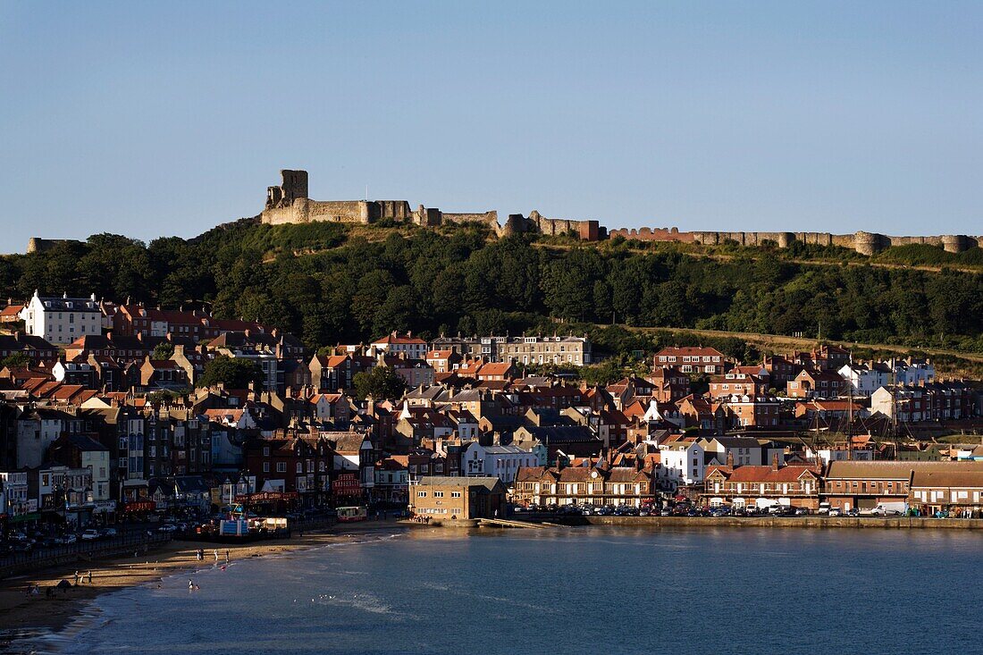 The Ruin of Scarborough Castle Looms Over The Town at Sunset Scarborough North Yorkshire England