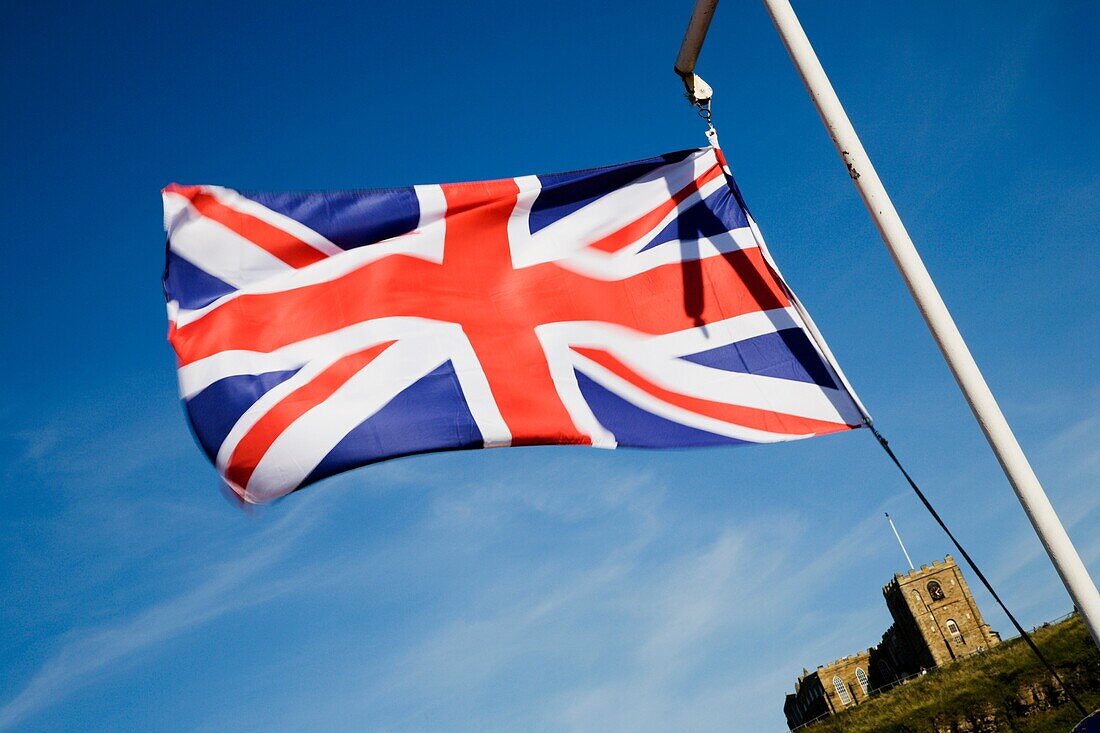Union Flag Flying on the Quayside with St Marys Church Beyond Whitby North Yorkshire England