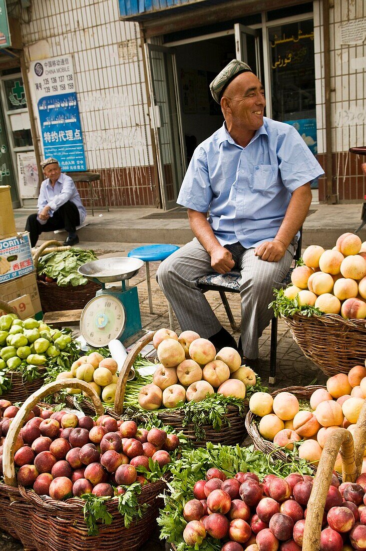 A fruit vendor selling his fruits in the vibrant markets in the old city of Kashgar, China.