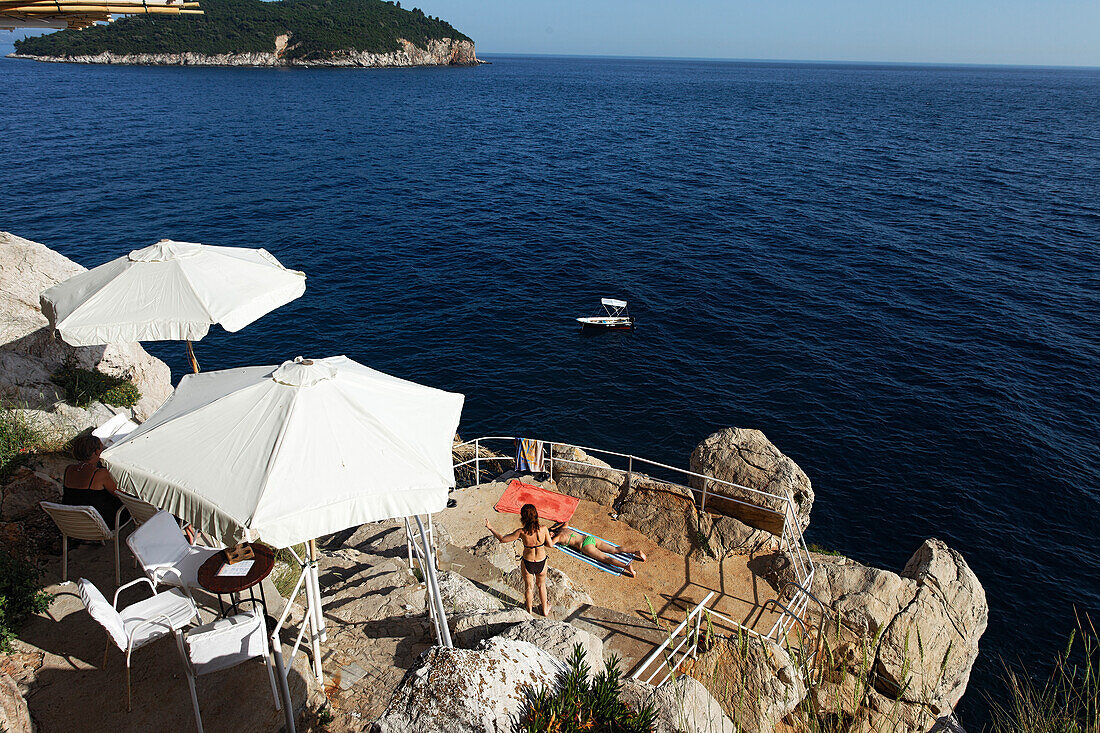 Young people sunbathing on rocks, Dubrovnik, Dubrovnik-Neretva county, Dalmatia, Croatia