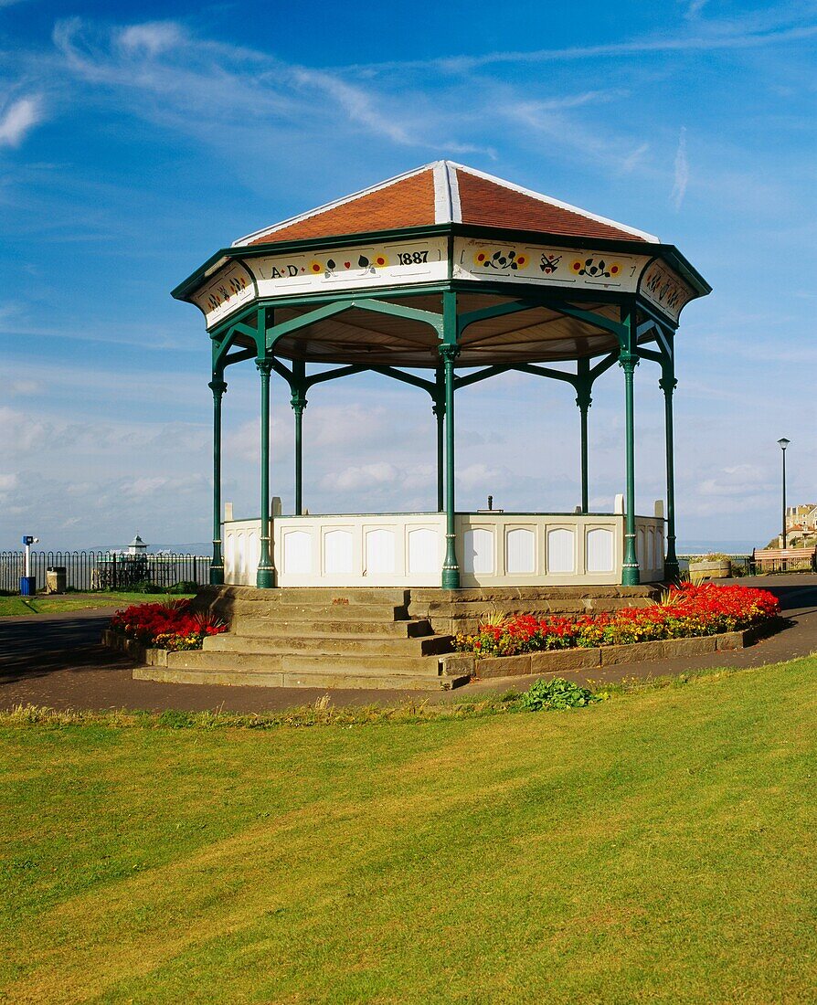 The bandstand on the seafront of Clevedon in Somerset, England In the distance can be seen the old Victorian pier in the Bristol Channel