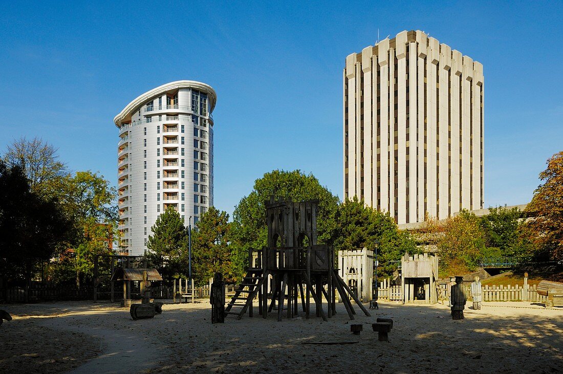The Cabot Circus tower and an older office block overlooking the children's play area at Castle Park, Bristol, England, United Kingdom
