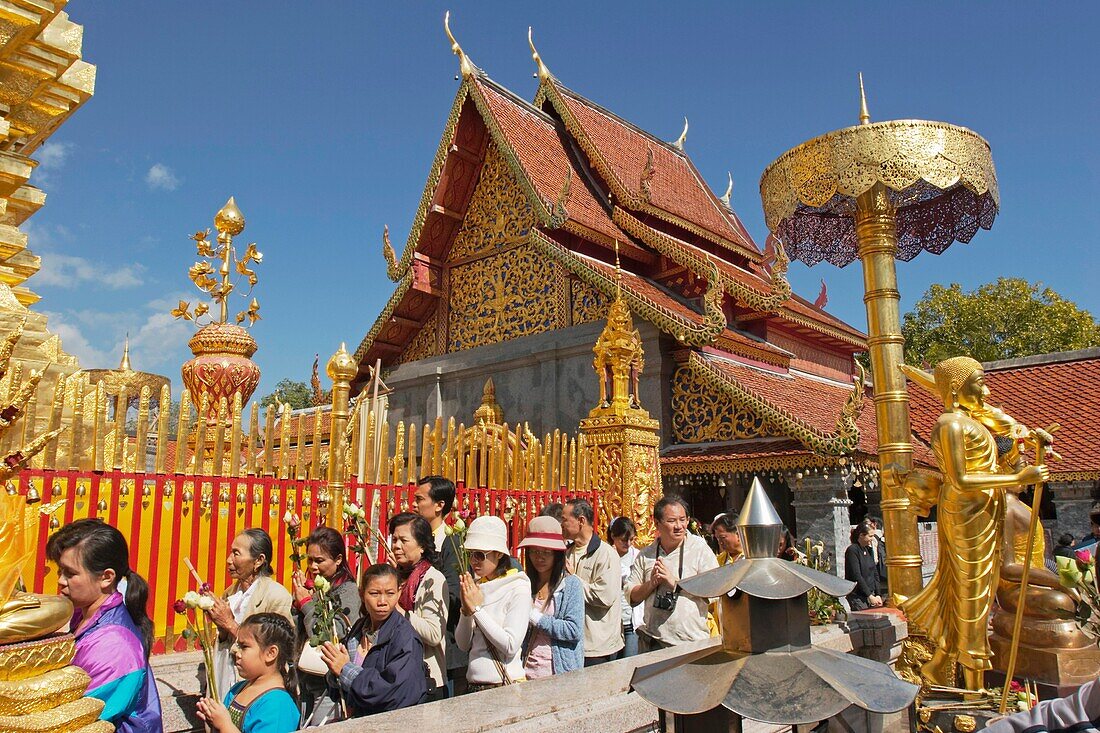People walking around the main pagoda in ritual ceremony in Wat Phrathat Doi Suthep Chiang Mai, Thailand