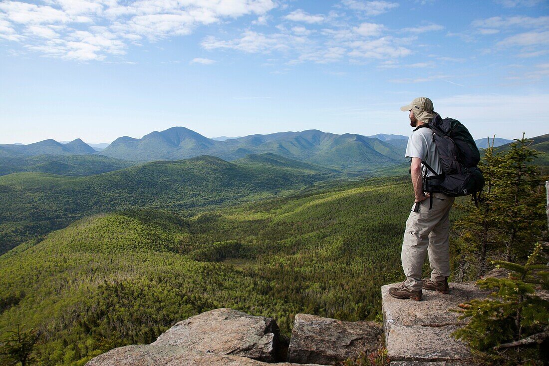 Zealand Notch - A hiker takes in the views from the summit of Zeacliff during the summer months Located along the Appalachian Trail in the White Mountains, New Hampshire USA