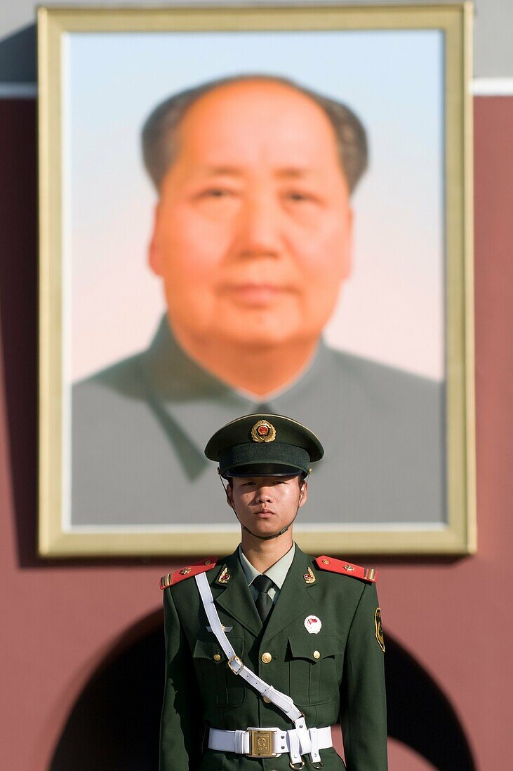 Guard standing in front of a portrait of Mao at the Forbidden City Beijing Chinap