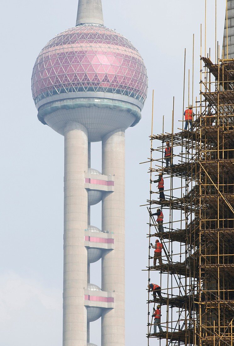 Construction workers on scaffolding near the Oriental Pearl Shanghai China