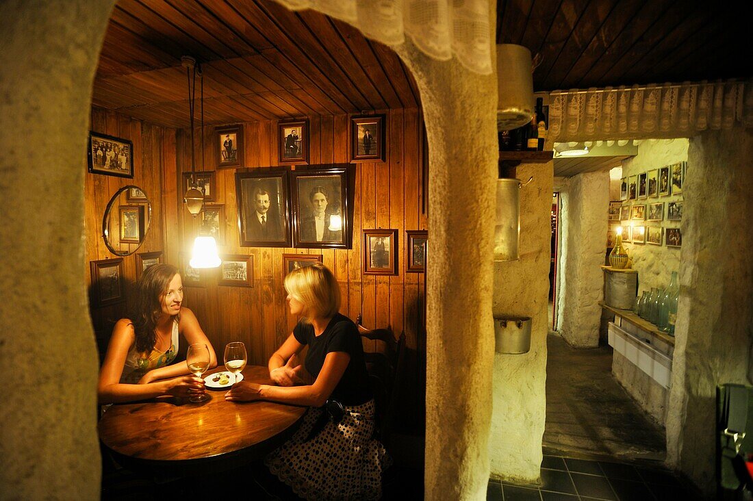 two young women tasting wine in the cellar of Gloria restaurant, Tallinn, estonia, northern europe