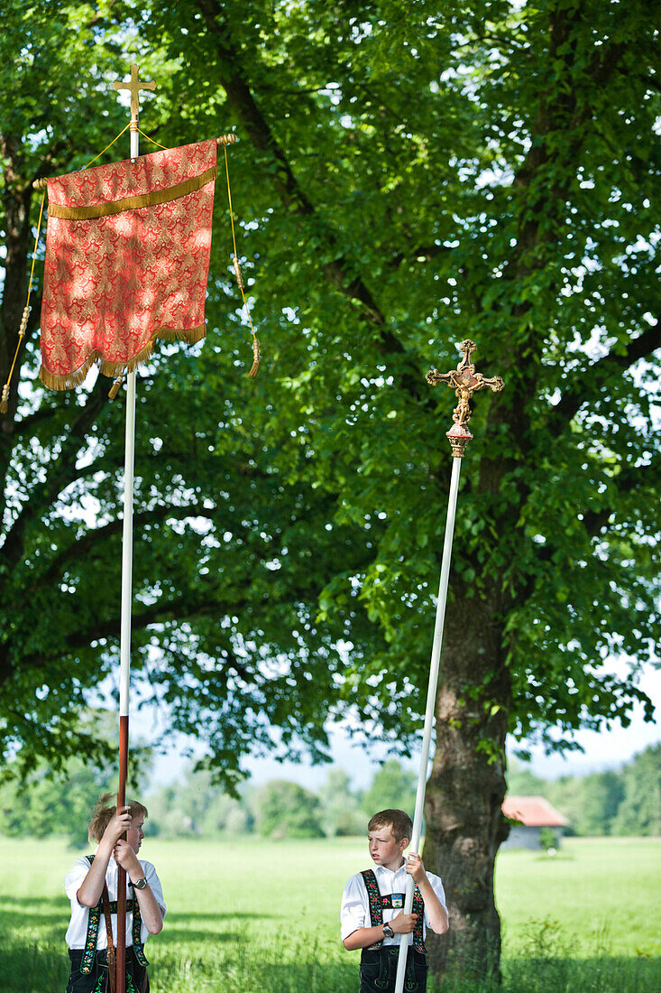 Two boys holding a flag and a cross, Corpus Christi procession,  Benediktbeuern, Alpine foreland, Upper Bavaria, Bavaria, Germany