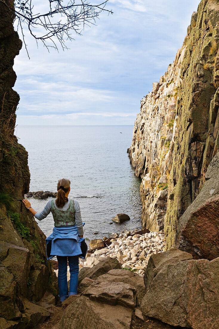 Frau an den Felsklippen Jons Kapel, Bornholm, Dänemark, Europa